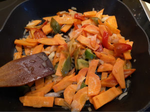 Слегка обжаренные лук, морковь и болгарский перец на сковороде