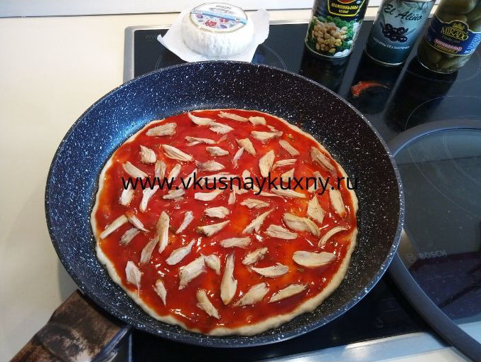 Раскладываем куриное мясо поверх томатного соуса для пиццы равномерно