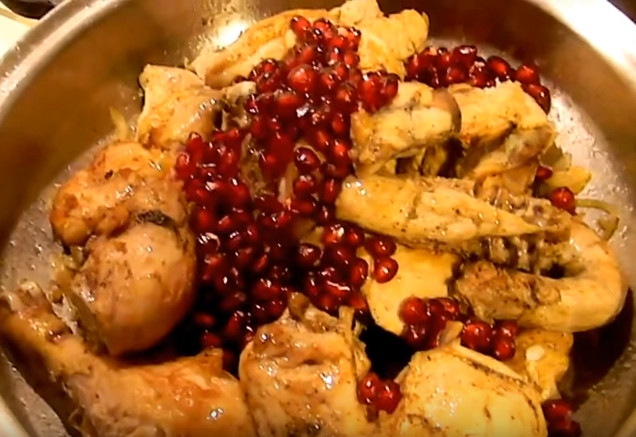 Курица в луке с зернами граната в сковороде
