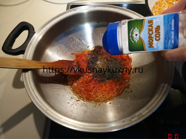 Добавляем соль в обжаренный лук с томатной пастой в кастрюле ВОК