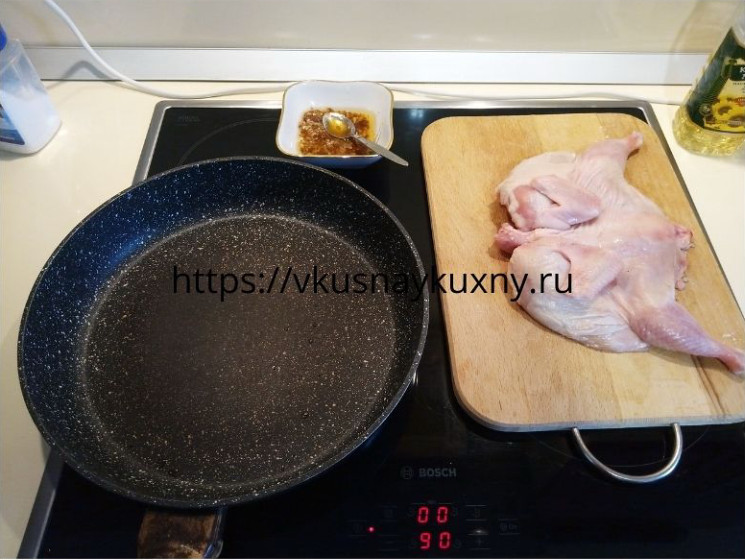 Подготовленный для жарки цыпленок табака на сковороде